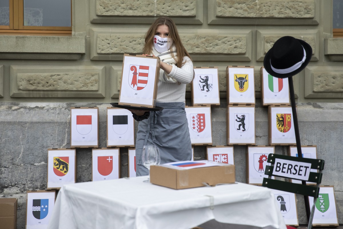 Stephanie Gartenmann, Junge SVP und Vorstandsmitglied Junge AUNS, "serviert" eine Schachtel mit Unterschriften, bei der Einreichung der Petitionen "Lockdown stop" und "Beizen  ...