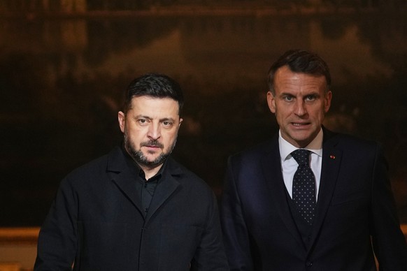 French President Emmanuel Macron, right, and Ukrainian President Volodymyr Zelenskyy arrive to give a joint press conference at the Elysee Palace in Paris, Monday, Dec 1, 2025. (AP Photo/Christophe En ...