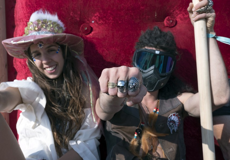 epa06733802 Israeli &#039; burners&#039; Daniel (R) and Luna (L) pose for a portrait on a chair in the desert as they attend the Israeli MidBurn Festival, near Sde Boker in the Negev Desert in souther ...