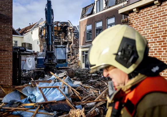 epaselect epa12653079 Heavy machinery moves amid the debris of damaged buildings in Visscherssteeg a day after a massive fire and explosion, in the historic city center of Utrecht, the Netherlands, 16 ...