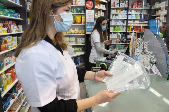 Eine Apothekerin zeigt abgepackte Coronavirus Antigen-Selbsttests, am Dienstag, 6. April 2021, in einer Apotheke in Stabio. Ab dem 7. April kann jede Person gratis fuenf COVID-19 Selbsttests pro Monat ...