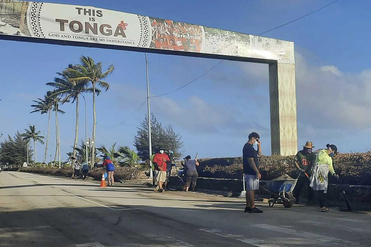 In this photo provided by Broadcom Broadcasting, people clear debris off the street in Nuku'alofa, Tonga, Thursday, Jan. 20, 2022, following Saturday's volcanic eruption near the Pacific arc ...