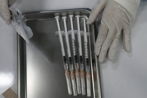 Syringes containing the Pfizer coronavirus vaccine are prepared at the Central Vaccination Center in Bangkok, Thailand, Monday, Jan. 10, 2022. (AP Photo/Sakchai Lalit)
