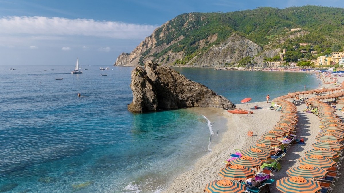 Kiesstrand Monterosso Urlaub Cinque Terre Monterosso al Mare Liegestühle und Sonnenschirme befüllen den Spiaggia di Fegina Strand, Monterosso