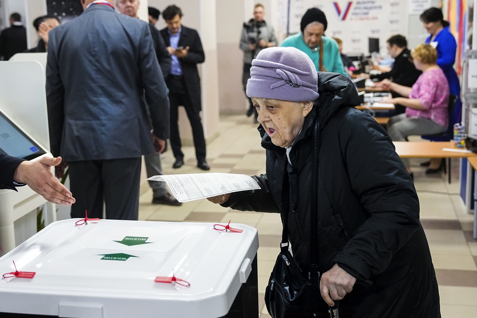 An elderly woman casts her ballot during a presidential election in Moscow, Russia, Saturday, March 16, 2024. Voters in Russia are heading to the polls for a presidential election that is all but cert ...