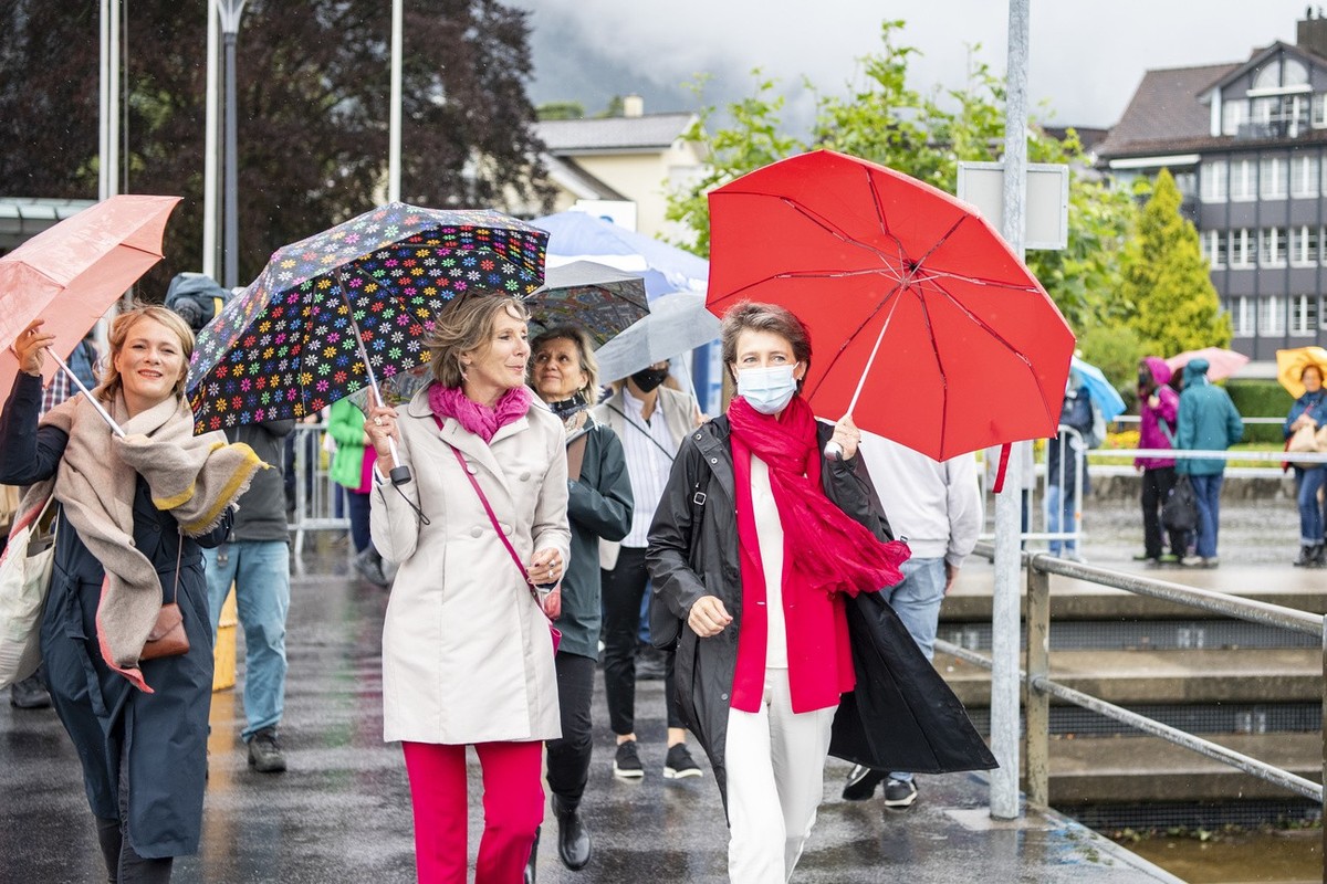 Bundesraetin Simonetta Sommaruga, rechts, bei windigen Wetter auf dem Weg zum Ruetlischiff in Brunnen waehrend der Bundesfeier auf dem Ruetli, welche im Zeichen von 50 Jahre Frauenstimmrecht steht, am ...