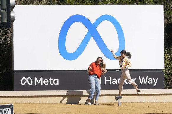 FILE - Facebook employees take a photo with the company&#039;s new name and logo outside its headquarters in Menlo Park, Calif., on Oct. 28, 2021. Meta, the company that owns Facebook, Instagram and W ...