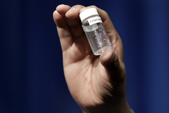 FILE - A reporter holds up an example of the amount of fentanyl that can be deadly after a news conference about deaths from fentanyl exposure, at DEA Headquarters in Arlington, Va., June 6, 2017. Los ...