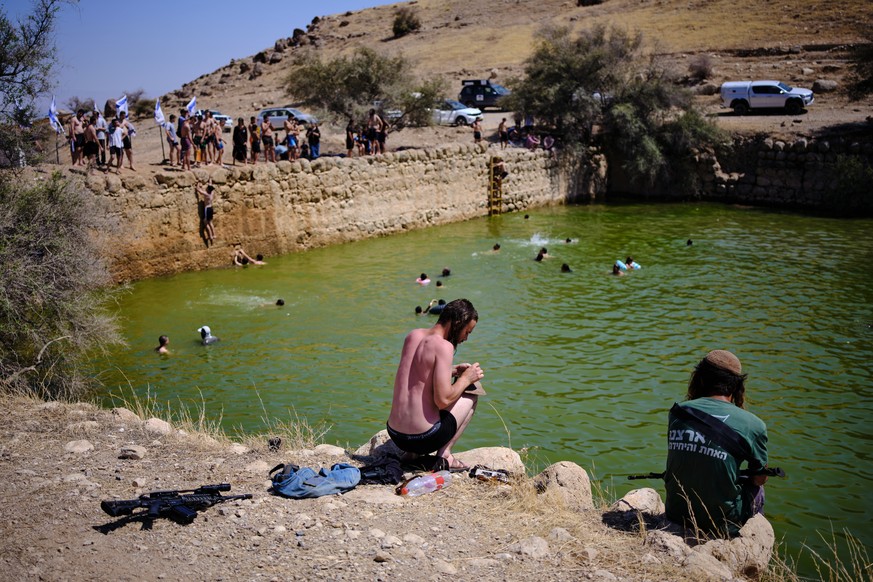 Israelis bathe at an ancient archaeological site known as Herod's Pool, near the Israeli settlement of Petzael in the occupied West Bank's Jordan Valley which was filled with water earmarked ...
