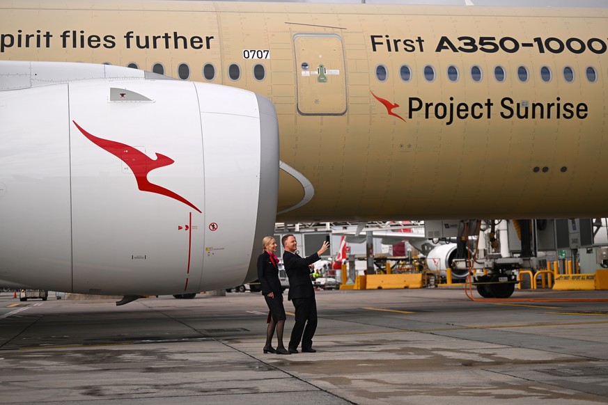 epa13129527 Qantas staff members take a selfie with an Airbus A350-1000ULR, developed for Qantas' Project Sunrise, during a media tour for an announcement by Australia's flag carrier airline ...