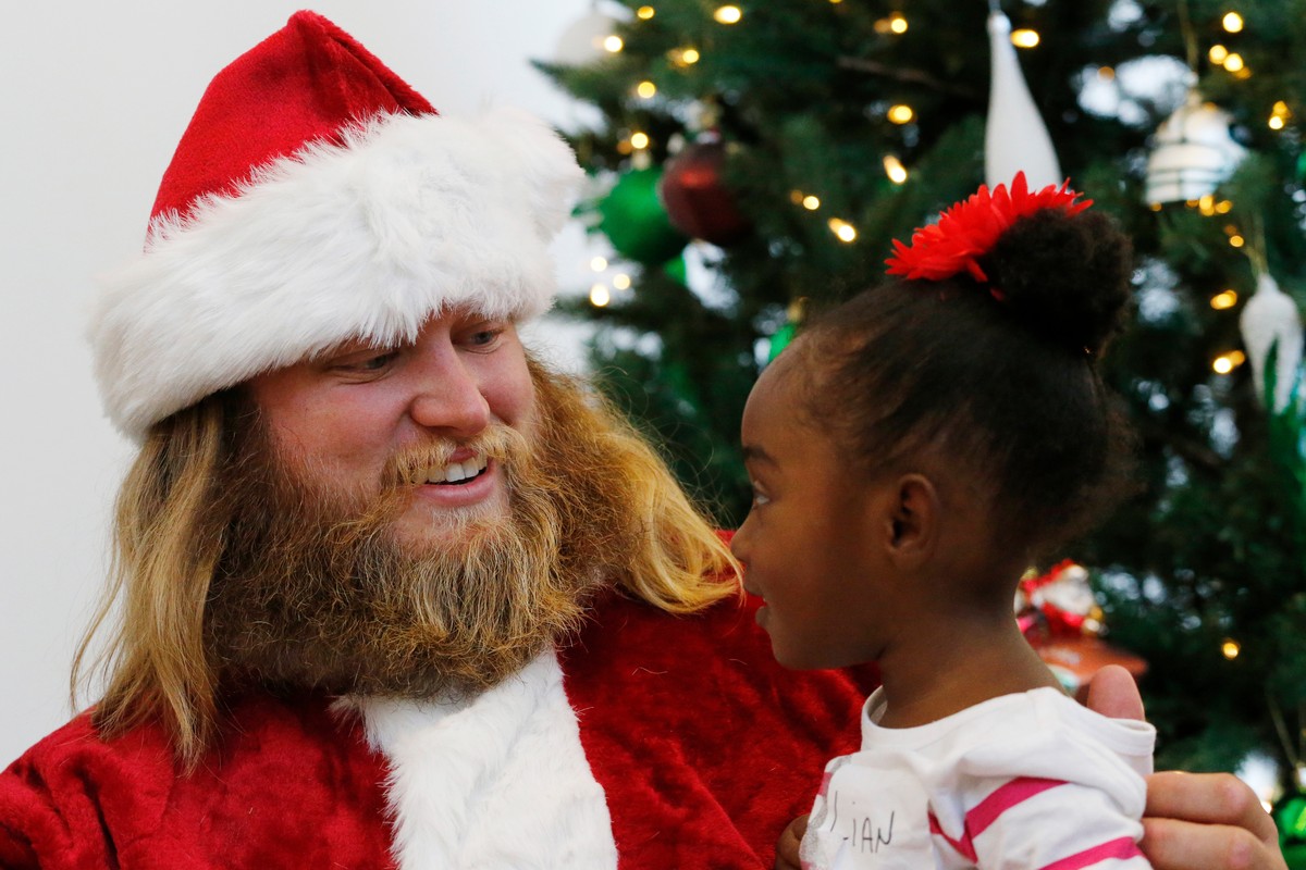 FILE - Lian Taylor, 2, right, of Bayonne, N.J., sits on the lap of New York Jets center Nick Mangold posing as Santa Claus during the team's holiday party for military families, Friday, Dec. 4, 2 ...