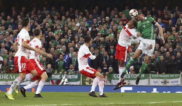 Northern Ireland's Gareth McAuley, right, and Switzerland's Manuel Akanji battle for the ball during the World Cup qualifying play-off first leg soccer match between Northern Ireland and Switzerland at Windsor Park in Belfast, Northern Ireland, Thursday Nov. 9, 2017. (Niall Carson/PA via AP)