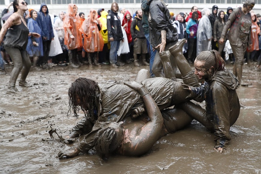 epa05352060 Rock fans dive in the mud at the Greenfield Openair, in Interlaken, Switzerland, 08 June 2016. The openair music event runs from 08 to 11 June. EPA/PETER KLAUNZER