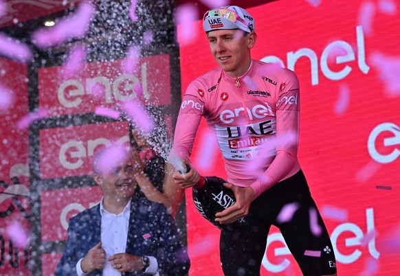 epa11348569 Slovenian rider Tadej Pogacar of UAE Team Emirates celebrates on the podium retaining the overall leader&#039;s pink jersey after the 13th stage of the Giro d&#039;Italia 2024, a 179 km cy ...