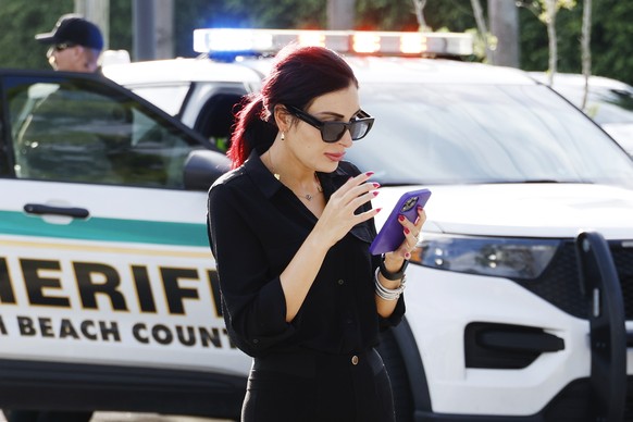 Laura Loomer uses her cell phone near Trump International Golf Club after police closed off the area following the apparent assassination attempt of Republican presidential nominee former President Do ...