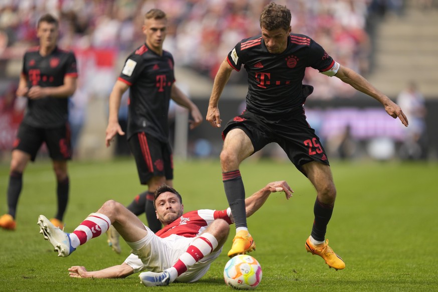 Bayern's Thomas Mueller, bottom, and Cologne's Jonas Hector challenge for the ball during the German Bundesliga soccer match between 1. FC Cologne and FC Bayern Munich in Cologne, Germany, S ...