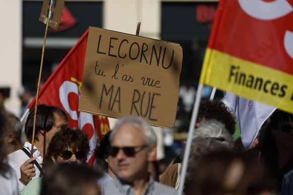 epa12422986 A protester holds a poster reading Lecornu did you see my street? as people demonstrate against government&#039;s austerity budget during an inter-Unions national day of protest in Montp ...