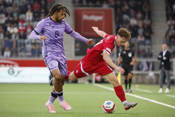 Koba Koindredi (FCB), links, und Michael Heule (FCT) in Aktion im Super League Spiel zwischen dem FC Thun und dem FC Basel, am Samstag, 13. September 2025 in der Stockhorn Arena in Thun. (KEYSTONE/Pet ...