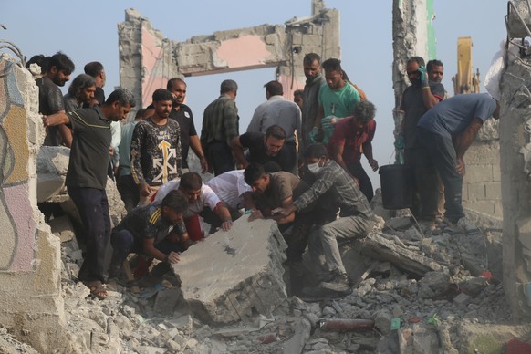 Rescue workers and residents search through the rubble in the aftermath of what Iranian officials said was an Israeli-U.S. strike on a girls' elementary school in Minab, Iran, Saturday, Feb. 28,  ...