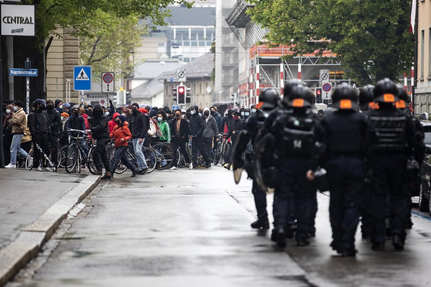 Polizisten stehen vor Demonstranten bei einer Demonstration zum Tag der Arbeit am Samstag, 1. Mai 2021 im Zentrum von Zuerich. Schweizweit sind am Samstag an ueber 30 Orten Veranstaltungen geplant, na ...