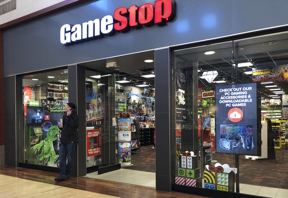 epa08971011 (FILE) - A man talks on a cell phone outside a GameStop store in Gurnee, Illinois, USA, 10 December 2019 (reissued 28 January 2021). The electronic game retailer has seen it's stock price  ...