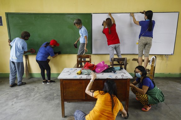 epa10121700 Volunteers clean up a classroom at the Sauyo High School in Quezon City, Metro Manila, Philippines, 15 August 2022. Volunteer parents, students, school staff and workers combined efforts i ...