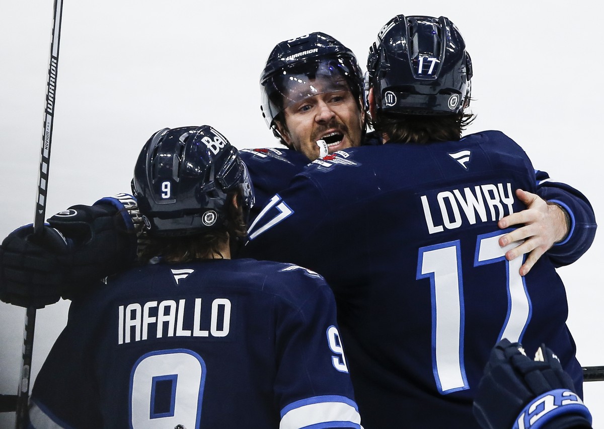 Winnipeg Jets' Alex Iafallo (9), Mark Scheifele (55) and Adam Lowry (17) celebrate after Lowry's goal against the St. Louis Blues during third-period NHL hockey game action in Winnipeg, Mani ...