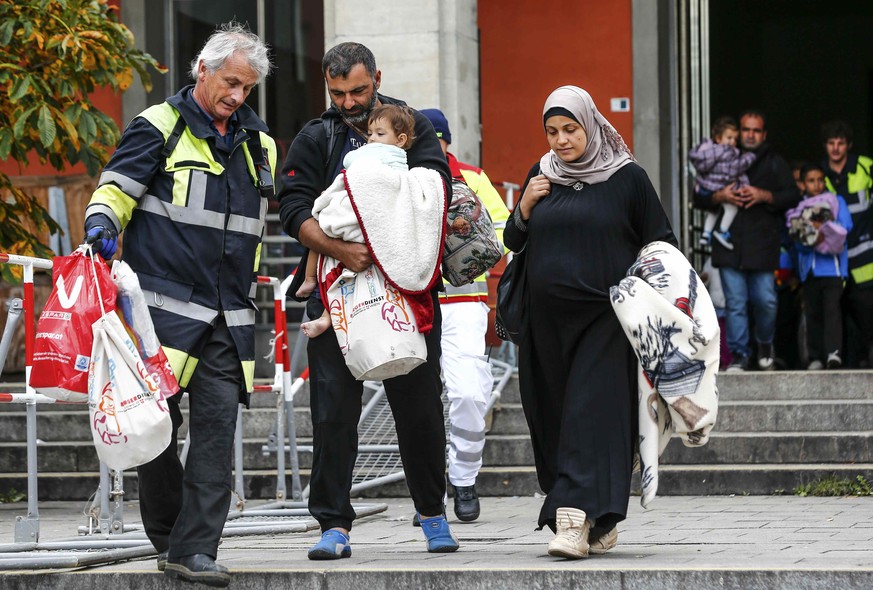 Endlich angekommen: Die Flüchtigen werden in München von diversen Helfern in Empfang genommen.