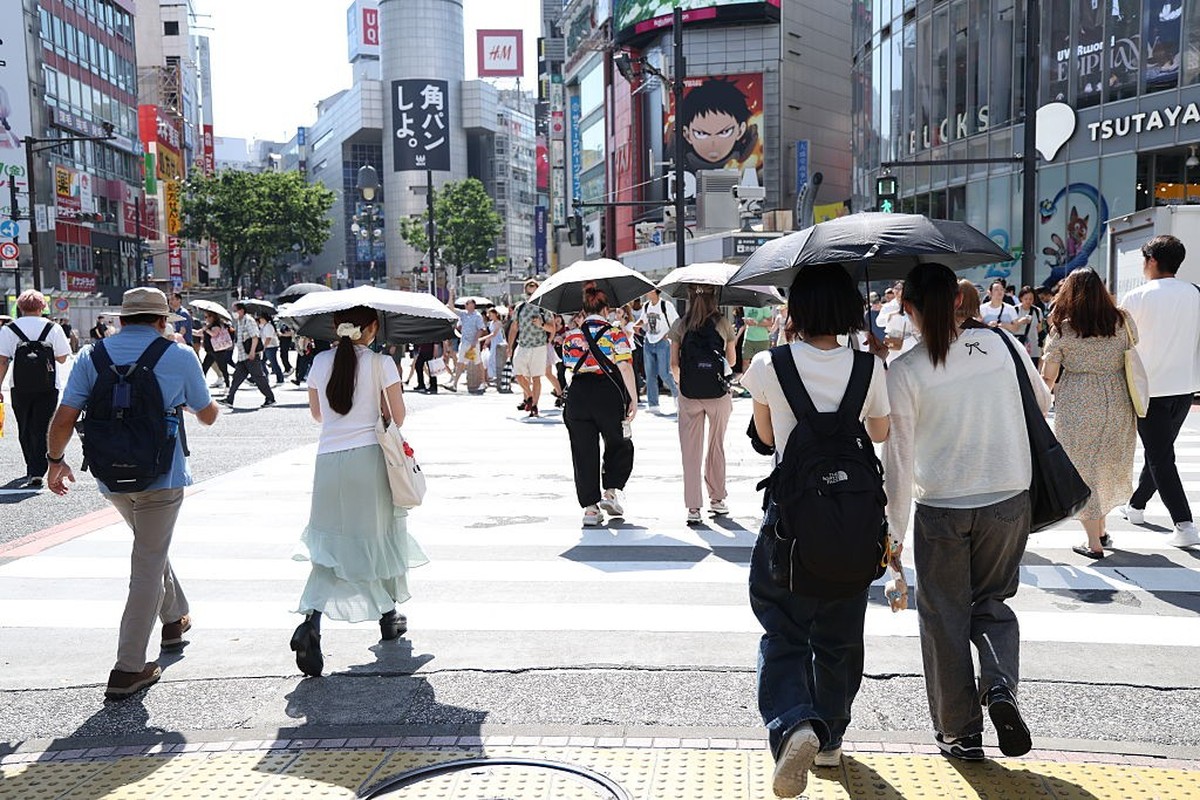 TOKYO, JAPAN - JUNE 16: People brave the intense heat armed with parasols and portable fans on June 16, 2025 in Tokyo, Japan. Tokyo recorded its first scorching day of the year, with temperatures hitt ...