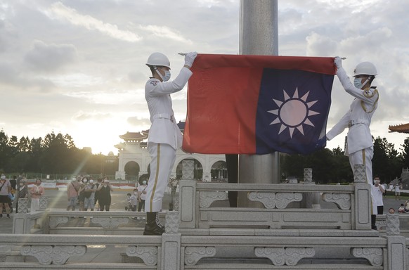 Two soldiers fold the national flag during the daily flag ceremony on the Liberty Square of Chiang Kai-shek Memorial Hall in Taipei, Taiwan, Saturday, July 30, 2022. (AP Photo/Chiang Ying-ying)