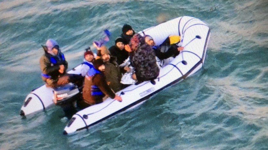 This image provided by the Marine Nationale (French Navy) shows migrants aboard a rubber boat after being intercepted by French authorities, off the port of Calais, northern France, Tuesday, Dec. 25,  ...