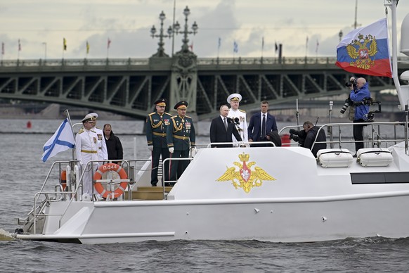 Russian President Vladimir Putin, center, Russian Defense Minister Sergei Shoigu, second left, Commander-in-Chief of the Russian Navy Admiral Nikolai Yevmenov, right of Putin, and Deputy Commander of  ...