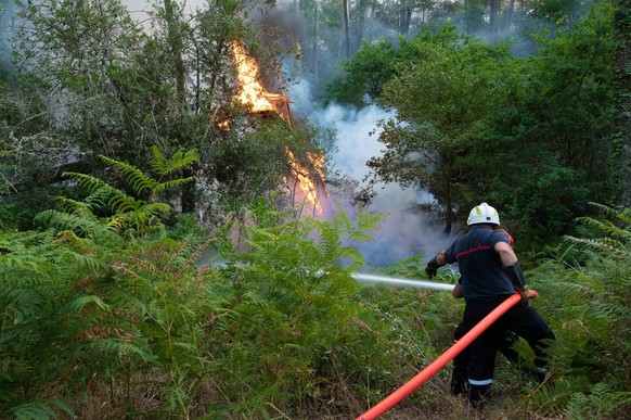 epa10069752 The forest of La Teste de Buch is filled with smoke from the fire, as firefighters fight the flames, in the South-West of France, 13 July 2022. The Gironde is facing two fires, one of whic ...