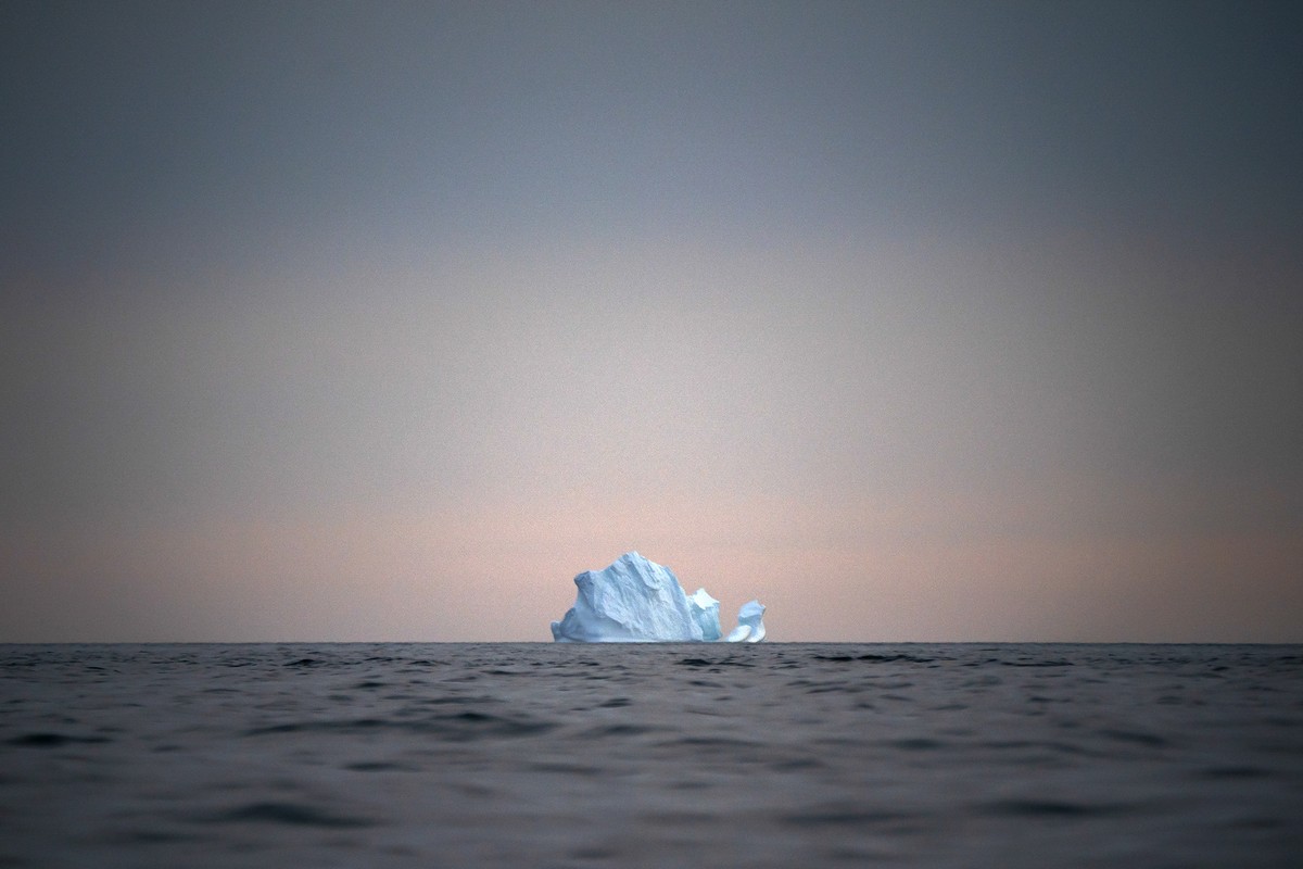In this Aug. 15, 2019, photo, a large Iceberg floats away as the sun sets near Kulusuk, Greenland. Greenland is where Earth's refrigerator door is left open, where glaciers dwindle and seas begin ...