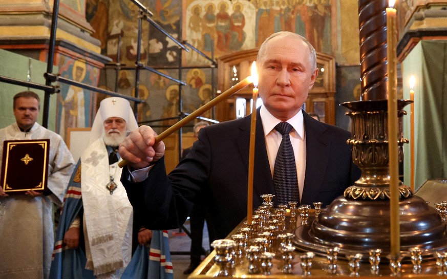 epa13180838 Russian President Vladimir Putin lights a candle during his visit to the Archangel Cathedral of the Kremlin, in Moscow, Russia, 20 August 2026. EPA/VYACHESLAV PROKOFYEV/SPUTNIK/KREMLIN / P ...