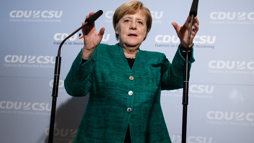 epa07046230 German Chancellor Angela Merkel delivers a statement to the media outside the CDU/CSU faction rooms after the election of Ralph Brinkhaus as the new parliamentary group leader at a joint m ...