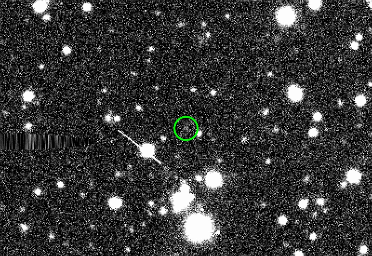 The sednoid 2023 KQ14 (in green circle) imaged by the Victor M. Blanco&amp;#039;s Dark Energy Camera on 7 June 2021. Surrounding white fuzzy circles are background stars and white fuzzy smudges and el ...
