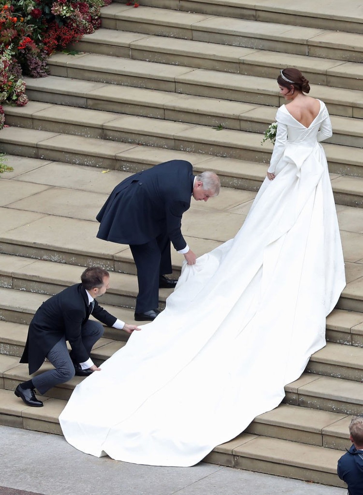 WINDSOR, ENGLAND - OCTOBER 12: Princess Eugenie of York receives help with her train from her father Prince Andrew, Duke of York as she arrives to her wedding to Mr. Jack Brooksbank at St. George' ...