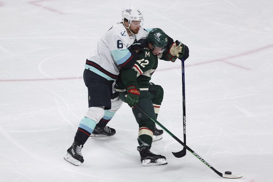 Minnesota Wild left wing Kevin Fiala (22) handles the puck against Seattle Kraken defenseman Adam Larsson (6) during the third period of an NHL hockey game, Friday, April 22, 2022, in St. Paul, Minn.  ...