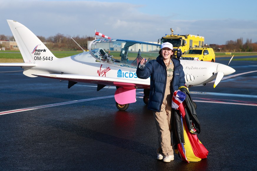 epa09696985 Belgian-British pilot Zara Rutherford poses for photographs in front of her small plane after landing in Wevelgem, Belgium, 20 January 2022. Zara, 19, broke the Guinness World Record for b ...