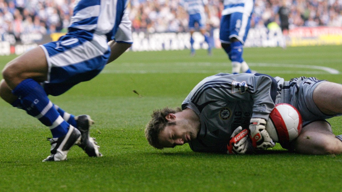 Chelsea's goalkeeper Petr Cech lies on the ground after a challenge by Reading's Stephen Hunt (L) in their English Premier League soccer match at the Madejski Stadium in Reading, southern En ...