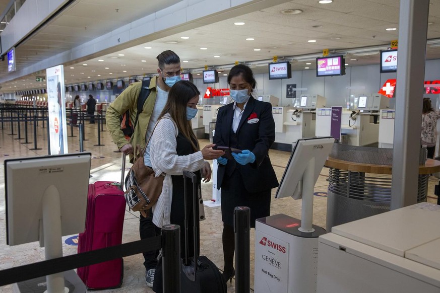 Eine Swissport-Mitarbeiterin kontrolliert die Tickets von Passagieren am Genfer Flughafen. Unbekannte haben das IT-System des Unternehmens attackiert – mit Folgen.