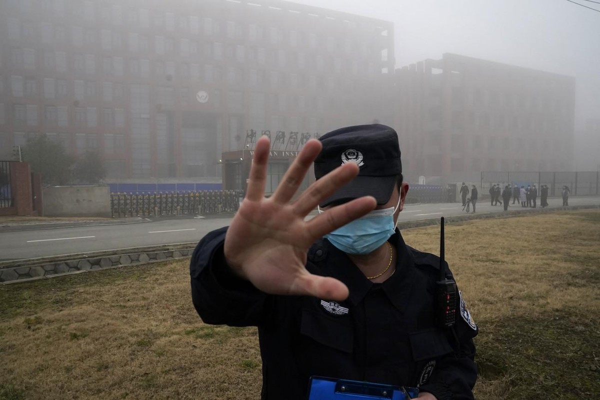 Un agent de sécurité éloigne des journalistes de l'Institut de virologie de Wuhan après l'arrivée d'une équipe de l'Organisation mondiale de la santé pour une visite sur le terrain ...