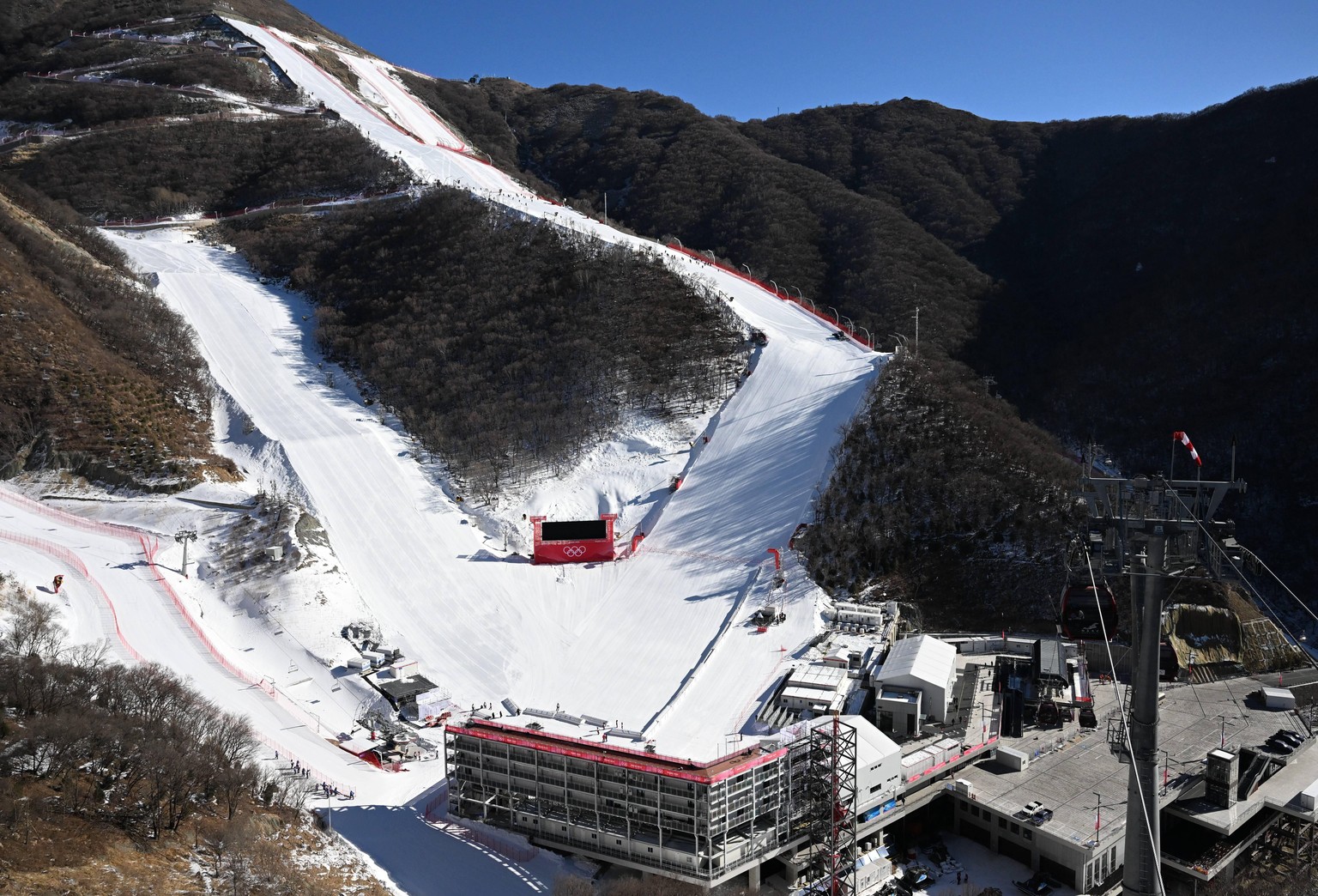 Sport Bilder des Tages (220129) -- BEIJING, Jan. 29, 2022 -- Staff members go to working area by cable cars at the National Alpine Skiing Center in Yanqing District, Beijing, capital of China, Jan. 28 ...