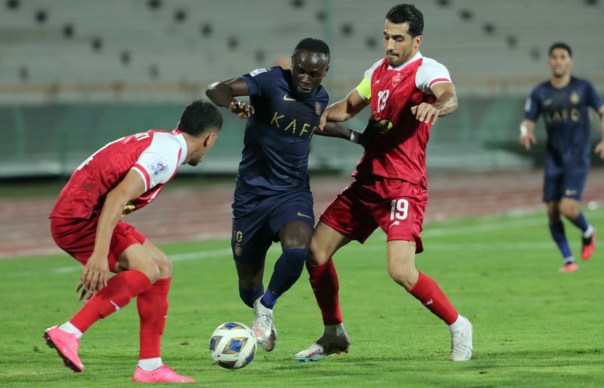 epa10870480 Vahid Amiri of Persepolis in action against Sadio Mane of Al-Nassr (C) during the AFC Champions League group E soccer match between Persepolis and Al-Nassr, in Tehran, Iran, 19 September 2 ...