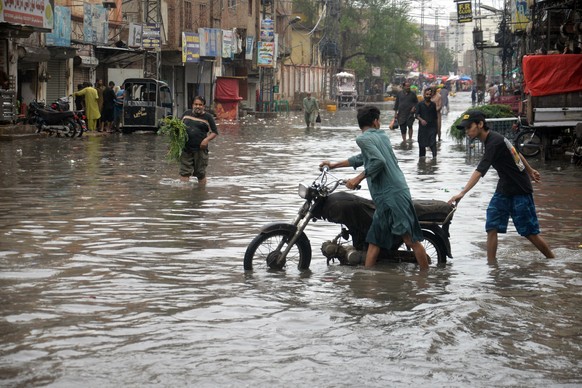 epa13147327 People wade through a flooded road during heavy monsoon rain in Hyderabad, Pakistan, 02 August 2026. Pakistan's disaster management and weather authorities warned that a new monsoon s ...