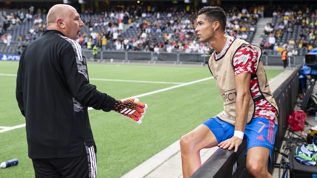 Manchester's Cristiano Ronaldo, right, gets back onto the pitch to Richard Hartis, Manchester's goalkeeping coach, after attending to a steward who got hit by one of his shots during warm up ...
