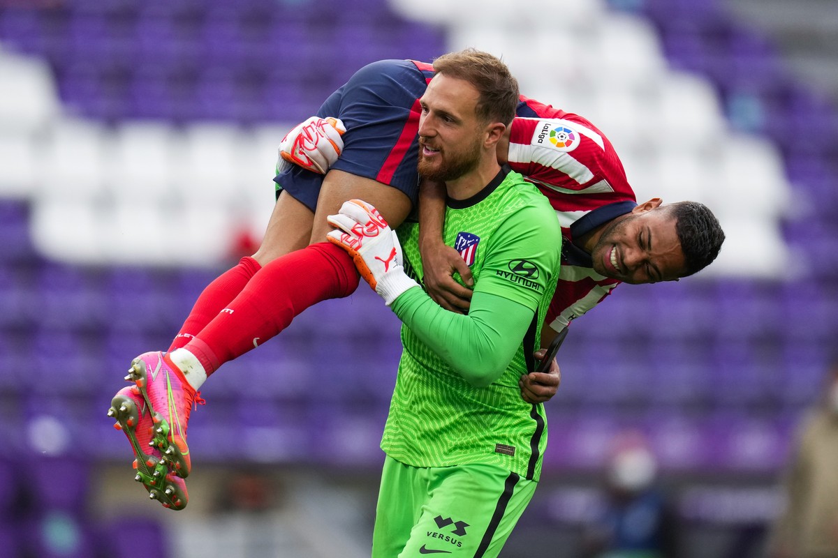 Atletico Madrid's goalkeeper Jan Oblak celebrates with teammate Renan Lodi, top, at the end of the Spanish La Liga soccer match between Atletico Madrid and Valladolid at the Jose Zorrilla stadium ...