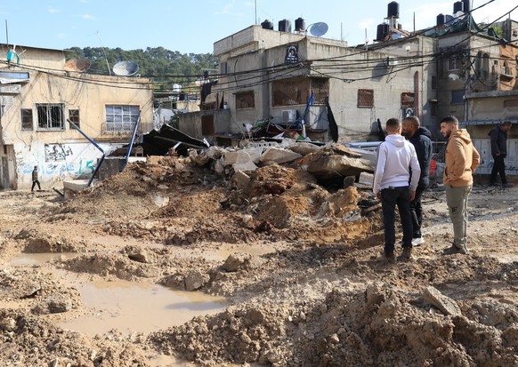 epa11233094 Palestinians inspect the damage following an Israeli raid at Nur Shams camp, near the West Bank city of Tulkarem, 21 March 2024. According to the Palestinian Ministry of Health, at least f ...