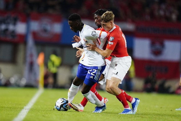 Belgium&#039;s Mandele Keita, left, challenges for the ball with Austria&#039;s Kevin Danso, centre, and Austria&#039;s Alexander Prass during the Euro 2024 group F qualifying soccer match between Aus ...